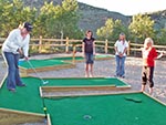 A young lady putts the ball across and uneven surface; one of many types of hazards in this game.